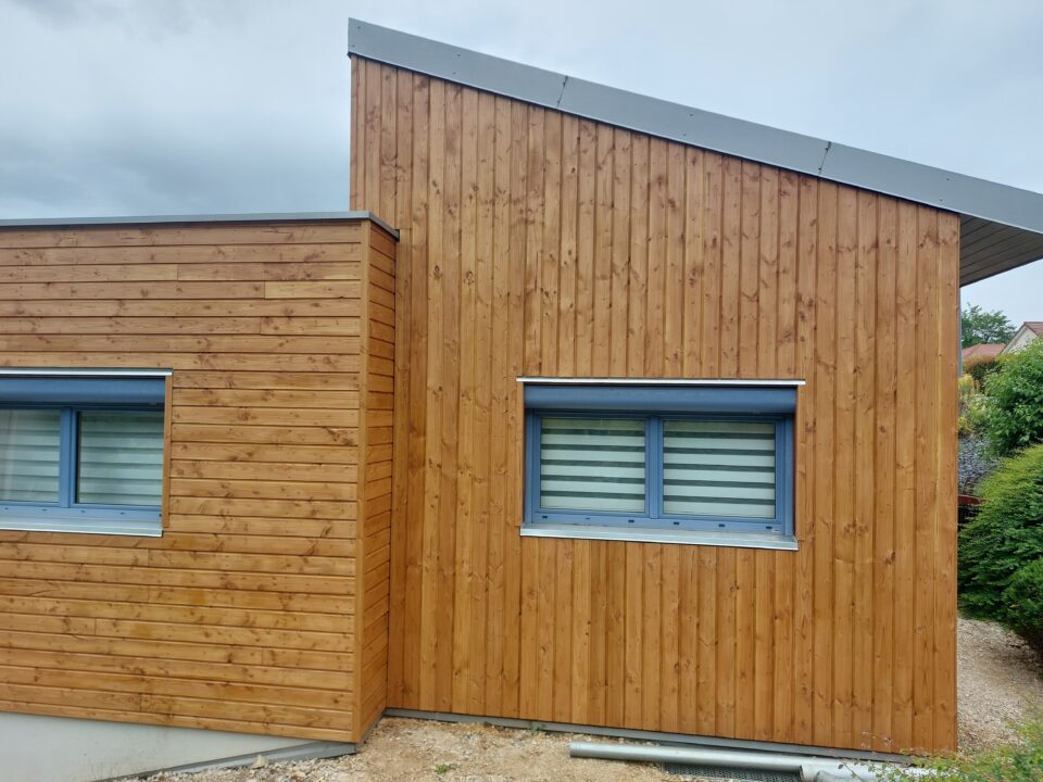 Bardage bois Douglas neuf posé verticalement et horizontalement sur une maison après rénovation.